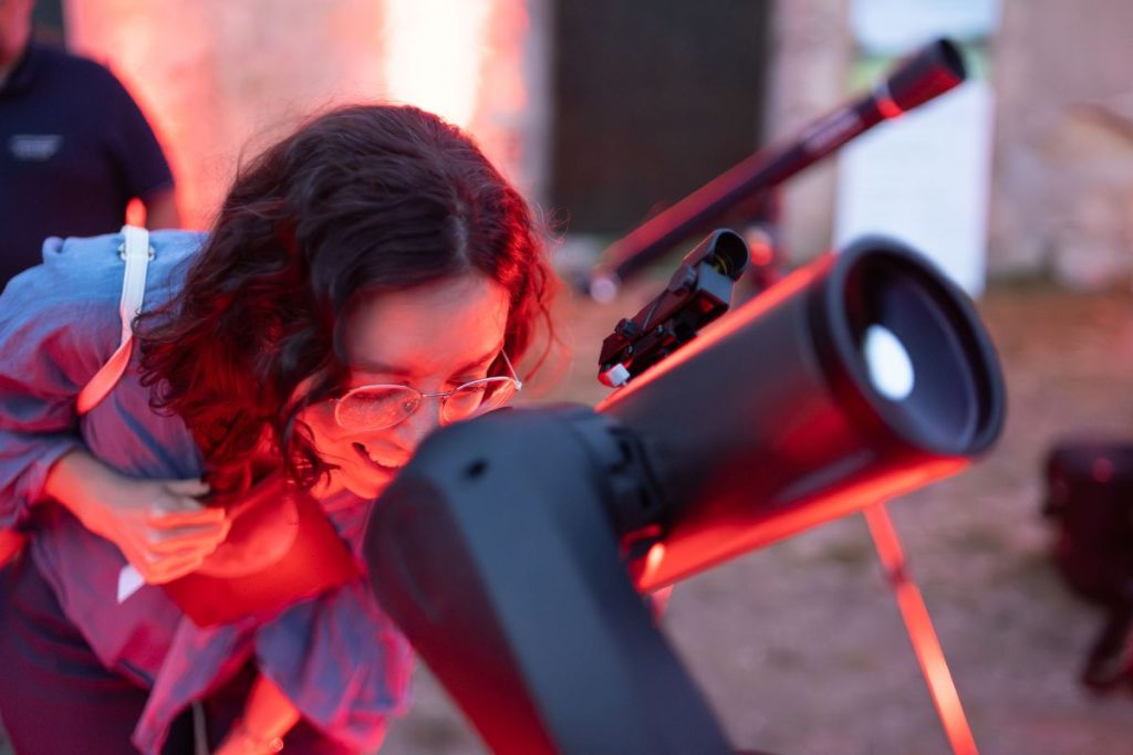 Ragazza che osserva al telescopio