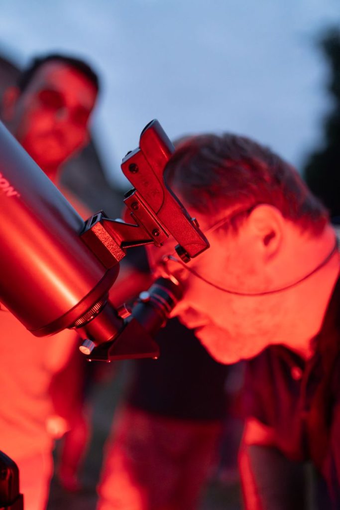 Signore che osserva da vicino al telescopio