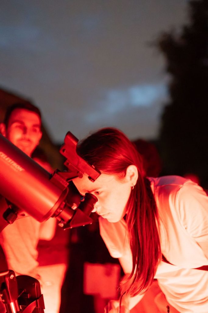 Ragazza osserva la luna e le stelle al telescopio