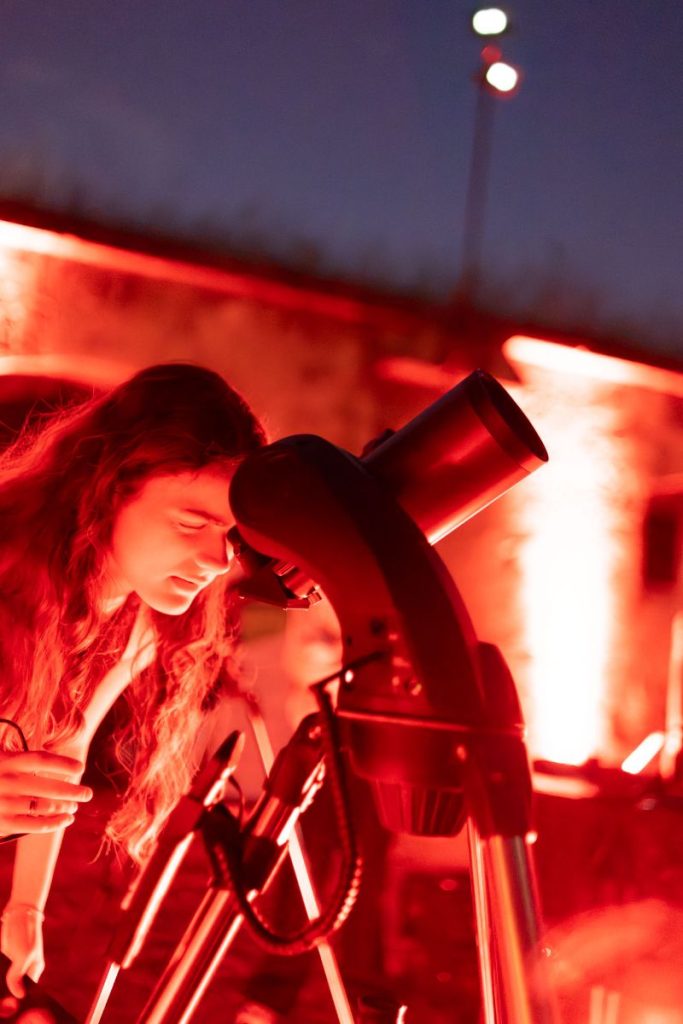 Ragazza osserva al telescopio la luna e le stelle durante la serata di "A riveder le stelle"